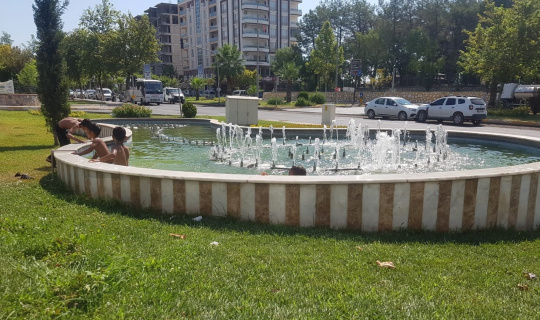 Sıcakta bunalan çocuklar süs havuzunda serinliyor